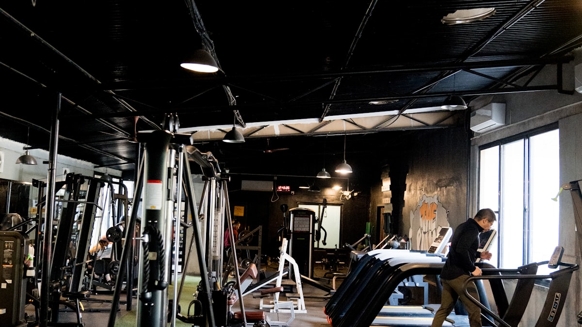 Visão geral de academia com equipamentos de musculação, ambiente típico de negócio fitness que precisa de gestão financeira e débito recorrente